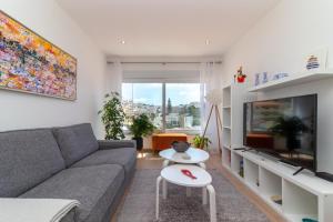 a living room with a couch and a tv at Casa Angelica in Praia do Carvoeiro