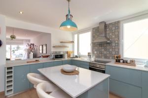 a kitchen with blue cabinets and a table with a bowl on it at Casa Angelica in Praia do Carvoeiro