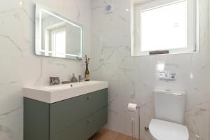 a bathroom with a sink and a toilet and a mirror at Casa Angelica in Praia do Carvoeiro +16 photos