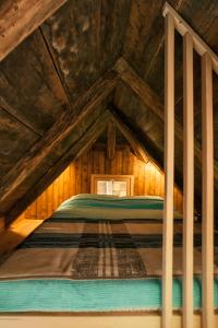a bed in the attic of a wooden house at Tiny house AMBAR in Starčevljani