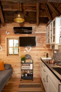 a kitchen with wooden walls and a couch in a room at Tiny house AMBAR in Starčevljani