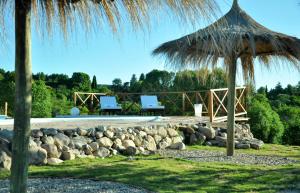 a patio with two chairs and an umbrella at Senderos del Tao in Las Rabonas