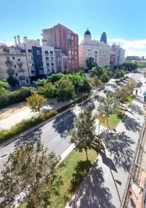an empty street in a city with trees and buildings at Clot MiraBarna Apartments in Barcelona