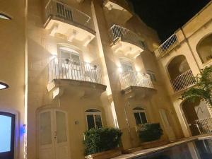 a large building with balconies on the side of it at GOZO TA CENC RESIDENCE WITH COMMUNAL POOL in Sannat