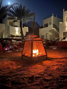 a fire pit in front of some buildings at night at Wadi Al Arbeieen Resort in Muscat