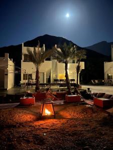 a courtyard with palm trees in front of a building at Wadi Al Arbeieen Resort in Muscat