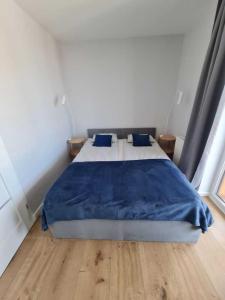 sypialnia z łóżkiem z niebieskim kocem w obiekcie Apartament CARO w mieście Mrzeżyno