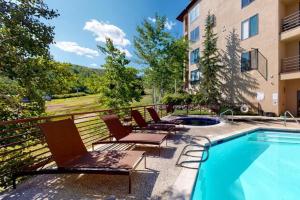 a balcony with chairs and a swimming pool at Snowmass Village, 3 Bedroom Condo at Chamonix, Ski-in Ski-out in Snowmass Village