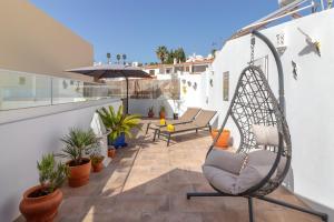 a patio with a swinging chair on a balcony at Casa Angelica in Praia do Carvoeiro