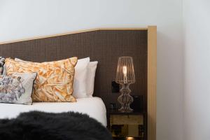 um quarto com uma cama e um candeeiro sobre uma mesa em QT Wellington em Wellington