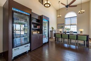 海斯的住宿－Comfort Inn & Suites Hays I-70，厨房以及带冰箱和桌子的用餐室。