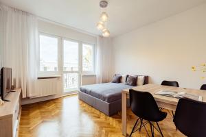 a bedroom with a bed and a table and chairs at Beach House Escape in Gdynia