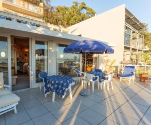 Villa Marina Guest House في كيب تاون: فناء مع طاولة وكراسي ومظلة