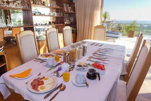 a table with a white table cloth with food on it at Villa Marina Guest House in Cape Town