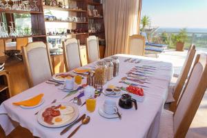 Villa Marina Guest House في كيب تاون: طاولة عليها قماش الطاولة البيضاء مع الطعام