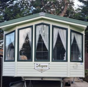 a white screened in porch with curtains on it at Modernised 3 Bedrooms Mobile Home in Sidcup