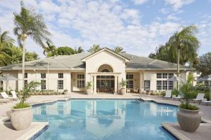 una piscina frente a una casa con palmeras en Stunning Centrally Located Apartments at New River Cove in South Florida en Fort Lauderdale