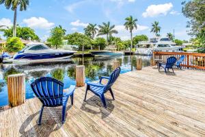 four chairs on a dock with boats in a marina at Stunning Centrally Located Apartments at New River Cove in South Florida in Fort Lauderdale