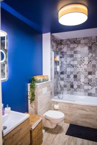 a blue bathroom with a toilet and a tub and a sink at YamaLux Apartments - HappyApartment - close to IuliusMall in Cluj-Napoca