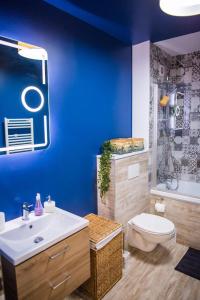a blue bathroom with a toilet and a sink at YamaLux Apartments - HappyApartment - close to IuliusMall in Cluj-Napoca