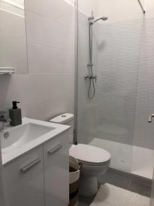 La salle de bains blanche est pourvue d'une douche et de toilettes. dans l'établissement Le Saint-Michel, à Menton