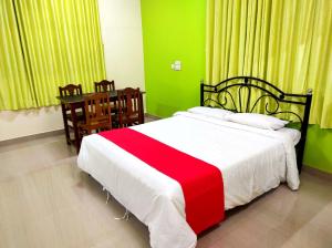 - une chambre avec un lit rouge et blanc et une table dans l'établissement SAHAY VILLA RESORT, à Durbate