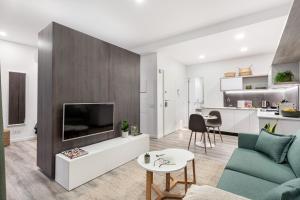 uma sala de estar com um sofá e uma televisão em Studios Terra & Mar em Lisboa