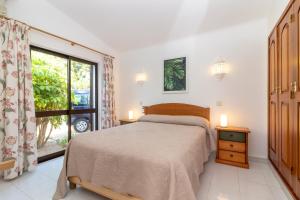 um quarto com uma cama e uma grande janela em Casa Santa Barbara em Carvoeiro