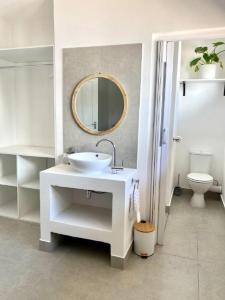 a white bathroom with a sink and a mirror at Angazi Guesthouse Unit 3 - Modern 2 Bedroom Apartment with Pool in Hillcrest