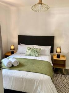 a bedroom with a large bed with towels on it at Angazi Guesthouse Unit 3 - Modern 2 Bedroom Apartment with Pool in Hillcrest