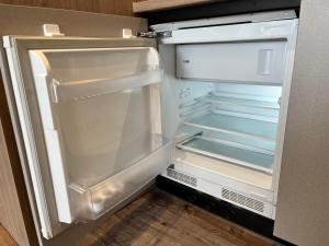 an empty refrigerator with its door open in a kitchen at Bel Mare Sunny Flamingo in Międzyzdroje