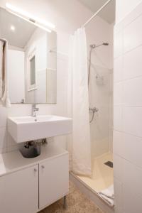 a white bathroom with a sink and a shower at Homenfun Barcelona Park Güell in Barcelona