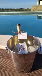 a bottle of wine in a metal bucket at Monte Clérigo Casas de Campo in Almodôvar