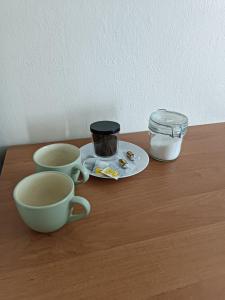 a table with two cups and a plate and a jar at Hostel Sunrise Liwska in Warsaw