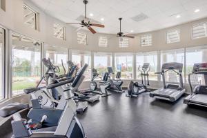 une salle de sport avec plusieurs tapis de course et machines elliptiques dans l'établissement Bright and Modern Apartments at Palm Trace Landings in South Florida, à Davie
