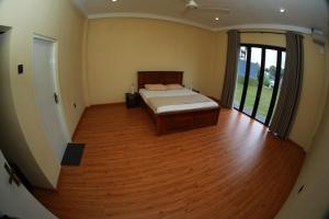 una camera con letto e pavimento in legno di Kosgama Riverside Resort a Kosgama