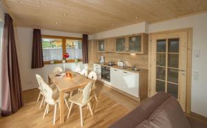 una cucina e una sala da pranzo con tavolo e sedie di Villa Mandl mit Garten Sauna Pool a Maishofen