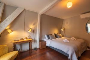 a bedroom with a bed and a table and two lamps at The Piano Guesthouse - Kwaadham52 in Ghent