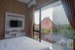 ein Schlafzimmer mit einem Bett und einem großen Fenster in der Unterkunft The Lavana Greenkhaza Villa Jogja in Yogyakarta + 37 Fotos