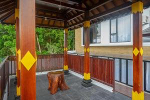 eine Veranda mit Baumstumpf und Holzbank in der Unterkunft The Lavana Greenkhaza Villa Jogja in Yogyakarta