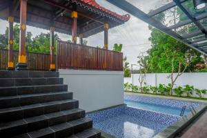ein Haus mit einem Pool und einer Treppe in der Unterkunft The Lavana Greenkhaza Villa Jogja in Yogyakarta
