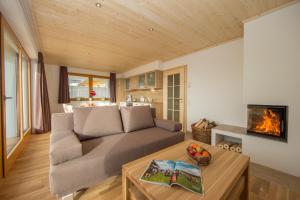 a living room with a couch and a table at Villa Mandl mit Garten Sauna Pool in Maishofen