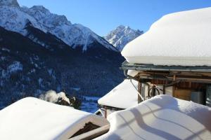 una casa coperta da neve con vista sulle montagne di Plazzetta 23 a Sent