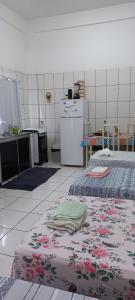 a kitchen with two beds and a refrigerator at Aluguel de loft mobiliado em Cuiabá in Cuiabá