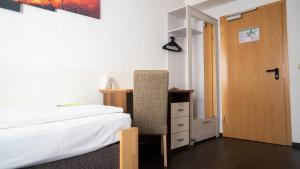 Schlafzimmer mit einem Bett, einem Schreibtisch und einer Tür in der Unterkunft Aalreuse in Rostock