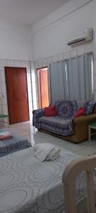 a bedroom with a bed and a couch in a room at Aluguel de loft mobiliado em Cuiabá in Cuiabá
