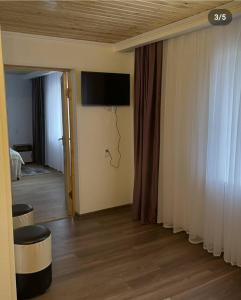 a room with a tv on the wall and a room with at Sunny Beach Hotel in Cholpon-Ata