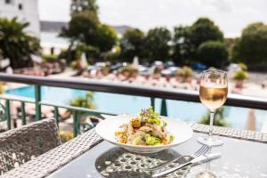 a table with a plate of food and a glass of wine at St Brelade's Bay Hotel in St Brelade