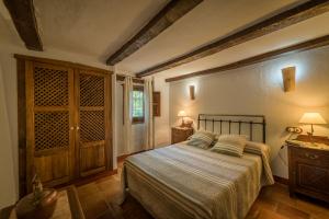 Un dormitorio con una cama y una puerta de madera. en Al Agia - Los Molinos de Padul, en El Padul