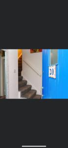 a stairway with a blue door and a sign that says at 20 Holiday Cottage, East End Ballybunion in Ballybunion